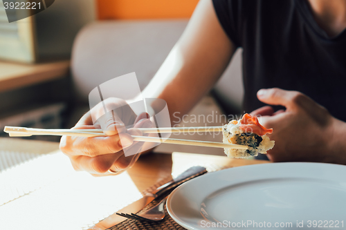 Image of girl eating sushi in restaurant