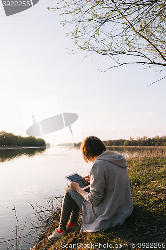 Image of girl working with tablet at the river