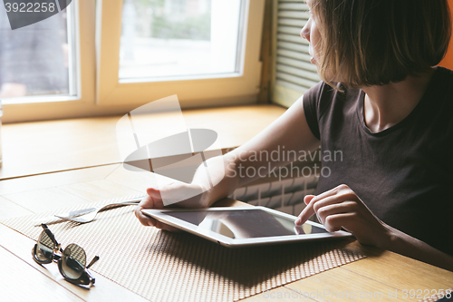 Image of girl works on the tablet