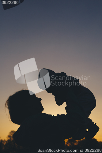 Image of mom with child at sunset