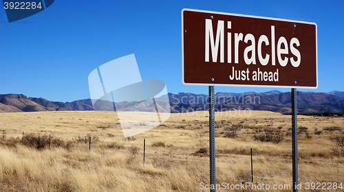 Image of Miracles Just Ahead brown road sign