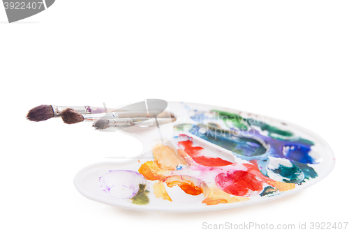 Image of Heavy used artist\'s palette with brushes 