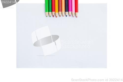 Image of Colour pencils and paper blank isolated on white background 