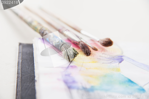 Image of paint brushes lying on painted background