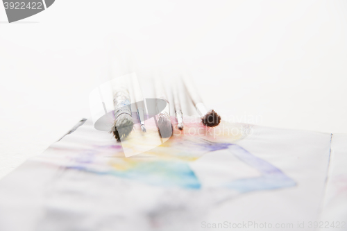 Image of paint brushes lying on painted background