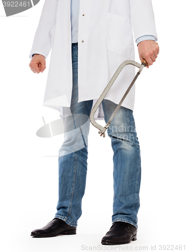 Image of Crazy doctor is holding a big saw in his hands