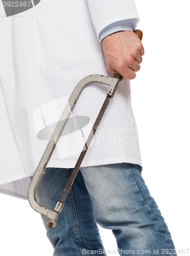 Image of Crazy doctor is holding a big saw in his hands