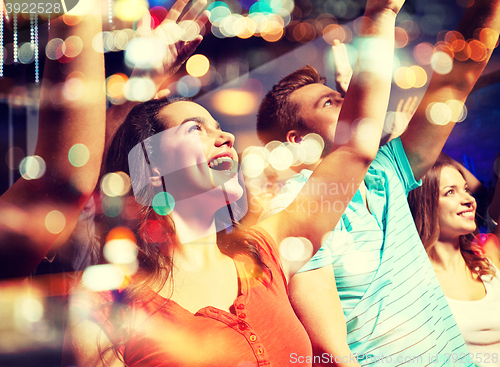 Image of smiling friends at concert in club