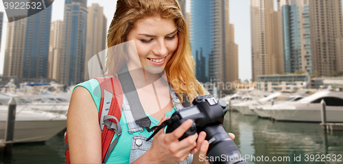 Image of woman with backpack and camera over dubai city