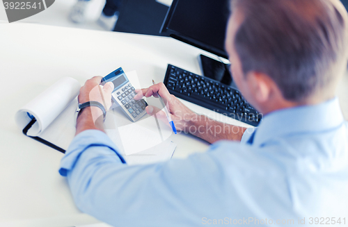 Image of businessman with notebook and calculator