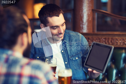 Image of male friends with tablet pc drinking beer at bar