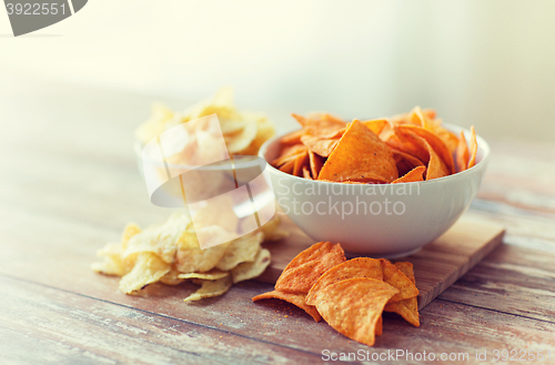 Image of close up of potato crisps and nachos in glass bowl