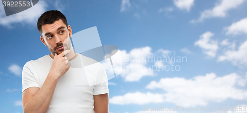 Image of man thinking over blue sky and clouds background