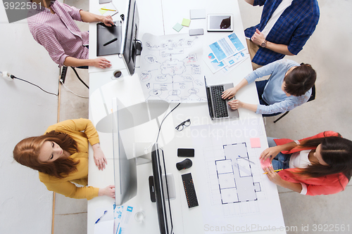 Image of creative team with computers, blueprint at office