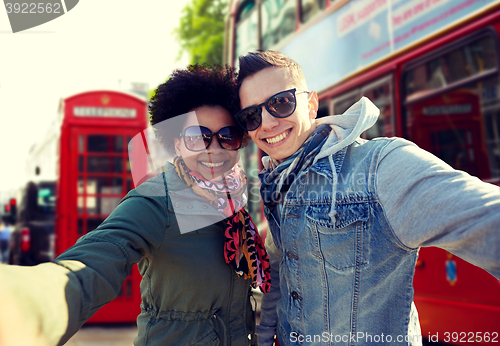 Image of happy teenage couple taking selfie in london city