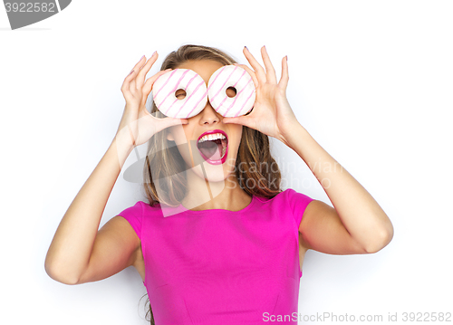 Image of happy woman or teen girl having fun with donuts