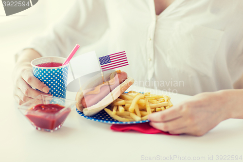 Image of close up of woman eating hotdog and french fries