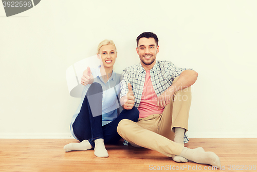 Image of happy couple showing thumbs up at new home