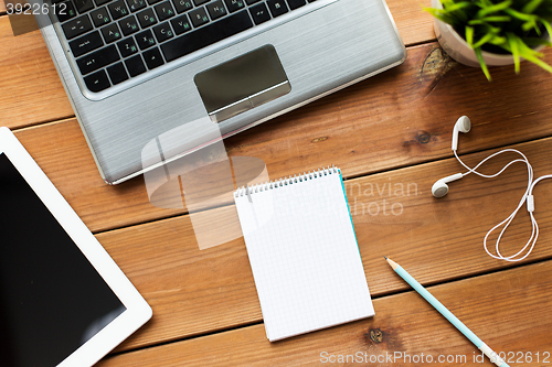 Image of close up of notebook, laptop and tablet pc on wood