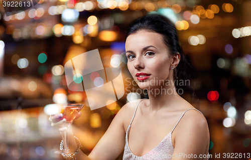 Image of glamorous woman with cocktail at night club or bar