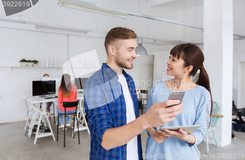 Image of couple with smartphone and tablet pc at office