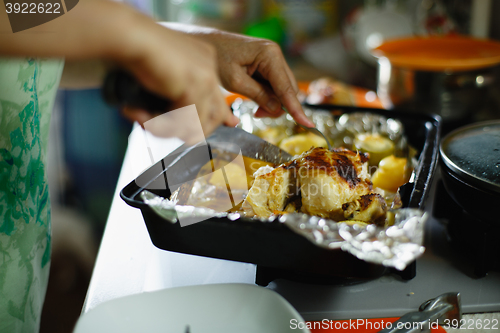 Image of woman cut a roasted chicken