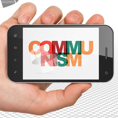 Image of Political concept: Hand Holding Smartphone with Communism on  display