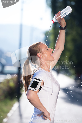 Image of woman drinking  water after  jogging