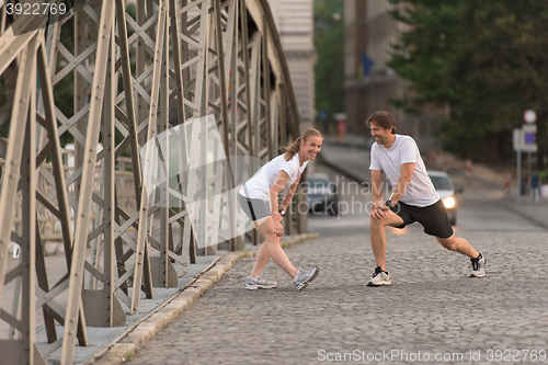 Image of couple warming up and stretching before jogging