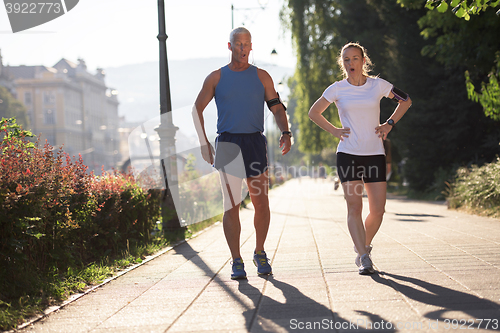 Image of jogging couple planning running route  and setting music