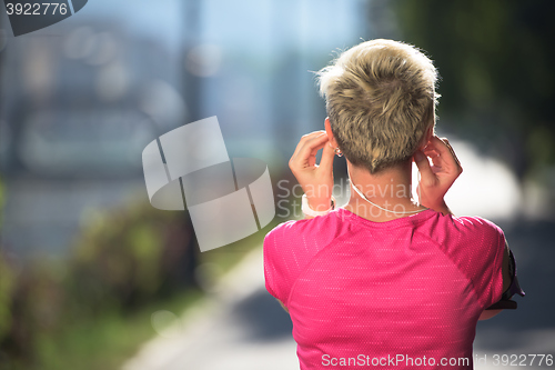 Image of jogging woman setting phone before jogging