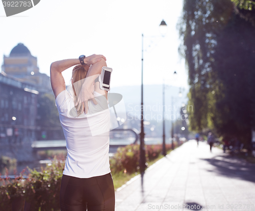 Image of blonde woman  stretching before morning jogging