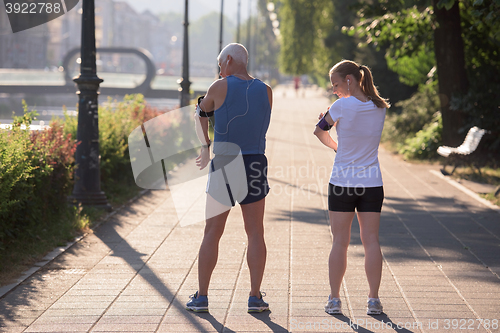 Image of jogging couple planning running route  and setting music