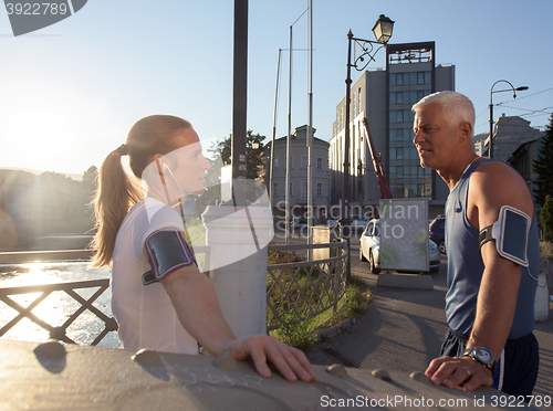 Image of jogging couple planning running route  and setting music