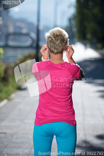 Image of jogging woman setting phone before jogging