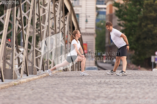 Image of couple warming up and stretching before jogging