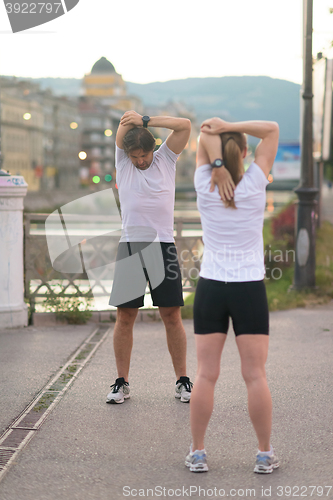 Image of couple warming up before jogging