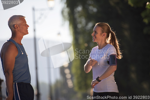 Image of jogging couple planning running route  and setting music