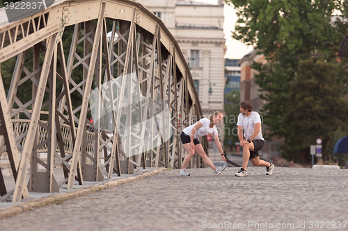 Image of couple warming up and stretching before jogging