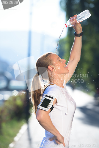 Image of woman drinking  water after  jogging