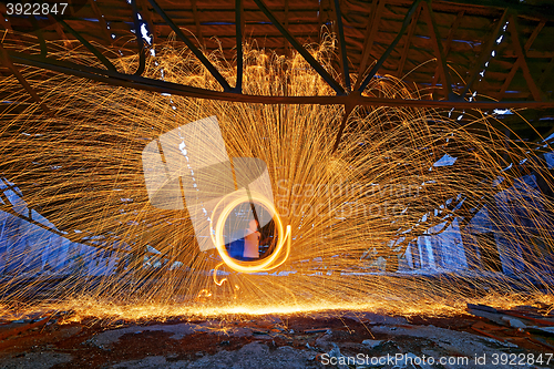 Image of Burning Steel Wool spinning. Showers of glowing sparks from spin