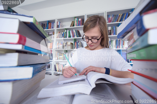 Image of female student study in library, using tablet and searching for 