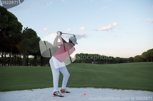 Image of golfer hitting a sand bunker shot on sunset