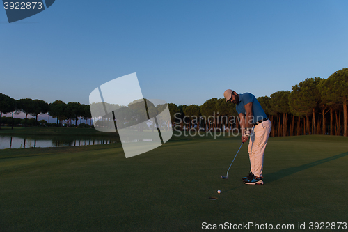 Image of golfer  hitting shot at golf course