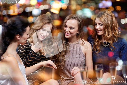 Image of woman showing engagement ring to her friends