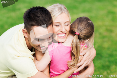 Image of happy family hugging outdoors