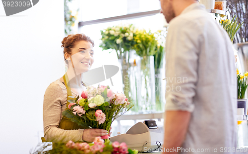 Image of smiling florist woman and man at flower shop