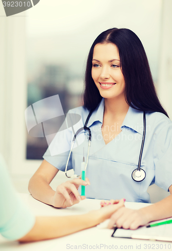 Image of smiling female doctor or nurse with syringe