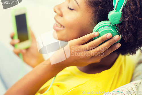 Image of happy african woman with smartphone and headphones