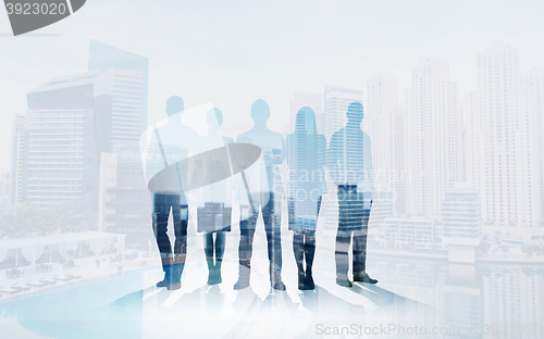 Image of business people silhouettes over city background